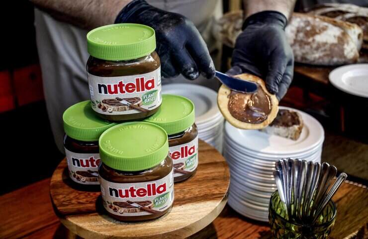 confezioni di nutella vegana e uomo che la spalma